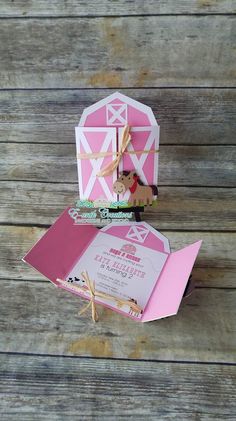 an open pink and white barn shaped card