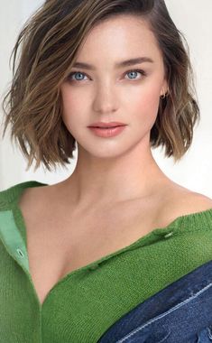 a woman with short hair wearing a green top