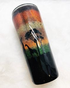 a black and orange can with giraffes on it sitting on a white surface