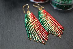 two pairs of beaded earrings sitting on top of a table