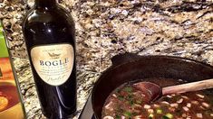 a bowl of soup next to a bottle of booze on a counter top with a box of booze