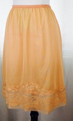 Vintage 50's over dyed mango orange colored slip skirt with lace trim and sheer inserts. Fabric is a soft silky rayon blend. Perfect as a summer skirt with sandals and a tank. Fits modern ladies' sizes 4-6 best.  22" total length 11 " flat waist stretches comfortably up to 15" flat waist  16" flat hip 21" flat hemline Summer Fitted Skirt With Delicate Lace, Fitted Summer Skirt With Delicate Lace, Fitted Delicate Lace Skirt For Summer, Summer Lace Bottoms With Lace Work, Fitted Summer Bottoms With Delicate Lace, Summer Skirt With Lace Trim And Stretch, Fitted Bottoms With Delicate Lace For Summer, Stretch Skirt With Lace Trim For Summer, Stretch Lace Skirt For Summer