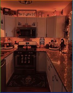 a kitchen with white cabinets and lights on the counter tops, along with a black stove top oven