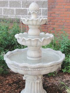 a water fountain in front of a brick wall