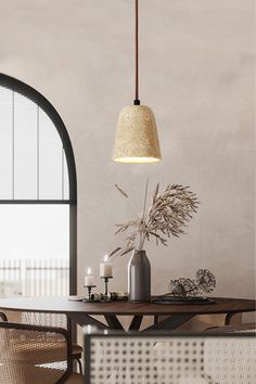 a dining room table with chairs and a vase on it, next to an arched window