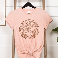 This super cute desert scene t shirt is a great gift for the cactus loving / nature loving woman, or pick one up for yourself.  ❤️Love the design and want it in a sweatshirt? We got you covered. Tap here:   SHORT SLEEVE TSHIRT FIT: ⚡️Tapered shoulder so it retains its shape even after washing. ⚡️crew neckline adds a timeless, classic touch and a neat appearance that is perfect for showcasing accessories like necklaces or scarves.  COMFORT / QUALITY / MATERIAL ⚡️Soft cotton & quality print ⚡️Poly Cactus T Shirt, Cute Desert, Cactus Scene, Texas Cowgirl, Scene Shirt, Cactus Tshirt, Cactus Shirt, Desert Scene, Adventure Shirt