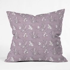 a lavender colored pillow with white flowers on the front and back, against a white background