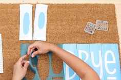 someone is cutting out letters on the door mat with scissors and tape to make them look like they are making numbers