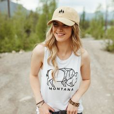 This simple bison design makes a bold statement. Show off one of our favorite Montana animals on this crisp white tank for summer, pair it with a flannel and make it the perfect tank for fall. Model is wearing a medium and usually wears a medium in ladies sizes. The muscle tank has a wider sleeve than our other tanks. Care InstructionsWash cold. Tumble dry on low. A Montana Scene Original Design. All designs are property of The Montana Scene. All rights reserved.All of The Montana Scene apparel Summer Casual Outdoor Tank Top, Summer Casual Tank Top For Outdoor, Casual Summer Outdoor Tank Top, Casual Summer Tank Top For Outdoor, Hiking Chic, Band Clothes, Summer Photo Shoot, Tactical Style, Outfits Amazon