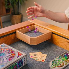 a person reaching for some dice on top of a table with other pieces in it