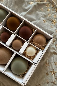 an open box filled with eggs on top of a bed