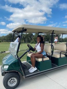 a woman is sitting in a golf cart