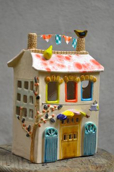 a ceramic house with two birds on the roof