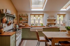 a kitchen filled with lots of counter top space and wooden furniture under a skylight