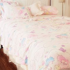 a white bed with pink and blue bedspread