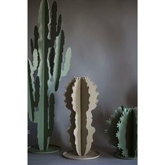 three green and white cactus sculptures sitting next to each other