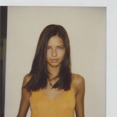 a woman with long hair wearing a yellow top