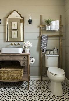 a bathroom with blue and white tile flooring next to a sink, toilet and mirror