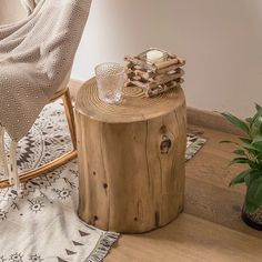 a wooden table sitting on top of a rug next to a chair and potted plant