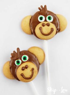 two monkey cookies with chocolate icing and eyes on top of each cookie, ready to be eaten