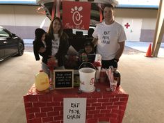 three people standing behind a table with food on it