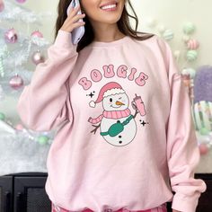 "Bougie Christmas Sweatshirt, Funny Snowman Crewneck, Pink XMAS Sweatshirt for Her, Christmas Shirt for Her, Cute Holiday Sweater, Girly Gift Embrace winter whimsy and humor with our \"Bougie\" Snowman Sweatshirt! This cute and funny design features a snowman sporting a stylish pink ensemble, exuding a touch of snowman swagger. Crafted for comfort and a dash of humor, this sweatshirt is the perfect way to showcase your playful side while staying cozy during the holiday season. Get ready to sprea Cute Winter Holiday Tops, Pink Tops As Winter Gifts, Cute Winter Sweatshirt Gift, Cute Winter Tops As Gift, Cute Winter Tops As A Gift, Cute Winter Sweatshirt For Gift, Cute Winter T-shirt For Loungewear, Cute Winter Tops For Loungewear, Cute Sweatshirt For Holiday Winter