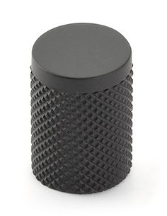 a black plastic container with holes on the top and bottom, sitting on a white surface