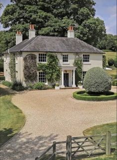 a large white house sitting on top of a lush green field