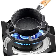 a black pot on top of a gas stove with blue flames in the burner