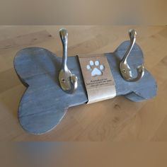 a dog's paw is attached to a metal hook on a wooden table top