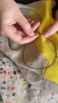 someone is stitching on the fabric with their hands