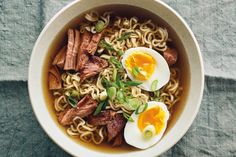 an overhead view of a bowl of noodles with meat and eggs