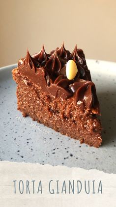 a piece of chocolate cake sitting on top of a blue plate with the words tortaglandula written below it