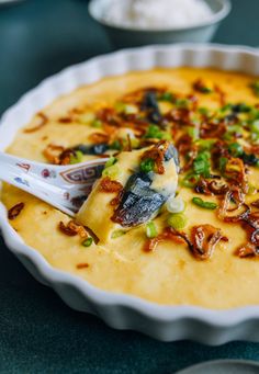 a bowl filled with cheese and toppings on top of a table