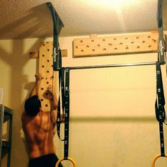 a man is doing pull ups on the gym equipment in front of an overhead bar