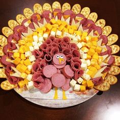 a turkey made out of crackers and cheeses on a platter for a thanksgiving dinner