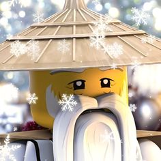 a lego man with a hat and scarf on his head, under an umbrella covered in snowflakes