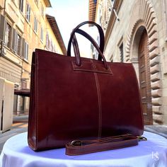 This bag has been made of the best genuine leather by local master crafters of Florence in Italy, designed for women who only accept premium Italian quality and luxury leather bags and modern Italian fashion. . Size: Width: 40 cm / 15.75 inches Height: 30 cm / 11.81 inches Depth: 11 cm / 4.4 inches Color: Dark Brown . The Story of this bag :  In the picturesque streets of Italy, where art and craftsmanship thrive, a story unfolds about a remarkable handmade leather bag that captures the essence of timeless beauty. This Italy leather bag is more than just an accessory; it is a masterpiece crafted with love and devotion by skilled artisans. As you hold this shoulder Italian bag in your hands, you can feel the passion and dedication that went into its creation. Each stitch, each fold, and eve Luxury Laptop Bag With Shoulder Strap, Designer Satchel Laptop Bag For Daily Use, Luxury Cognac Laptop Bag For Office, Designer Business Laptop Bag Tote, Elegant Cognac Laptop Bag For Business, Luxury Satchel Shoulder Bag With Laptop Sleeve, Luxury Shoulder Bag With Laptop Sleeve, Cognac Leather Laptop Bag For Work, Luxury Laptop Sleeve Satchel Shoulder Bag