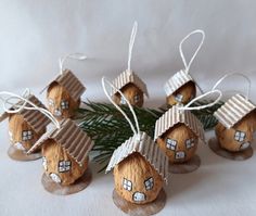 six small wooden houses with windows on them sitting next to a pine branch and white background