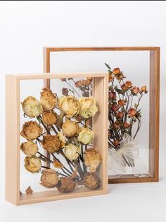 two wooden frames with dried flowers in them