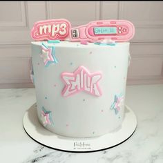 a white cake with pink and blue icing on it's top, decorated with stars