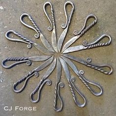 several pairs of scissors are arranged in a circle on the cement floor with twisted handles