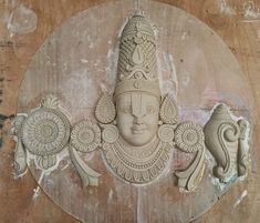 an intricately carved statue on the side of a wooden wall with two small sculptures