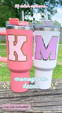 two personalized tumblers with the letter k and m on them are sitting on a picnic table