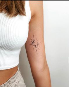 a woman's arm with a small sun tattoo on the left side of her arm