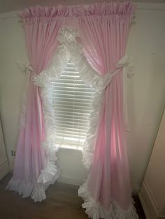 a window with pink curtains and white ruffles