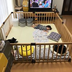 a small child laying on top of a bed in front of a tv