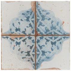 a blue and white tile design with leaves on the bottom, surrounded by brown grouting