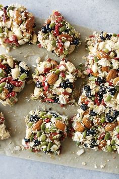 several pieces of fruit and nuts are arranged on a piece of parchment paper