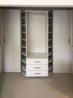 an empty walk in closet with white drawers